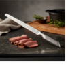 Cuchillo CRC de acero cortando sobre una tabla en una cocina.