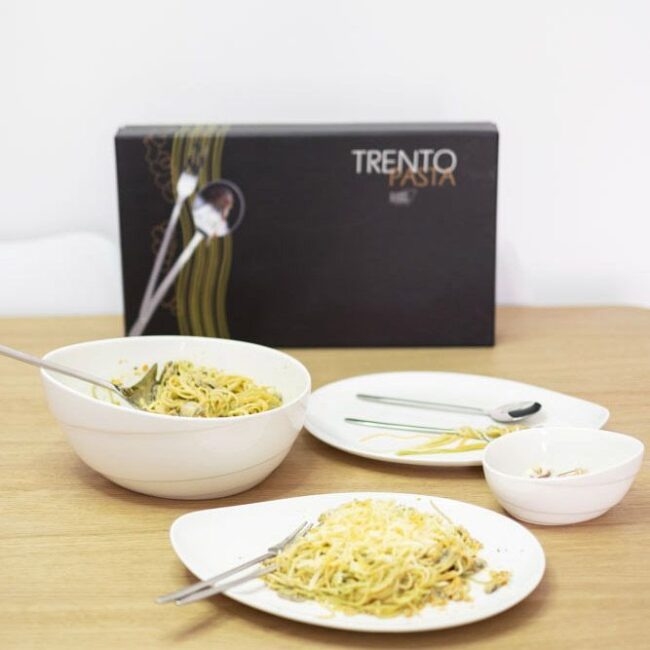 Cubiertos de pasta con platos y bol de ovum.