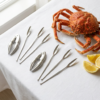 Set de utensilios para marisco con langosta y rodajas de limón sobre una mesa