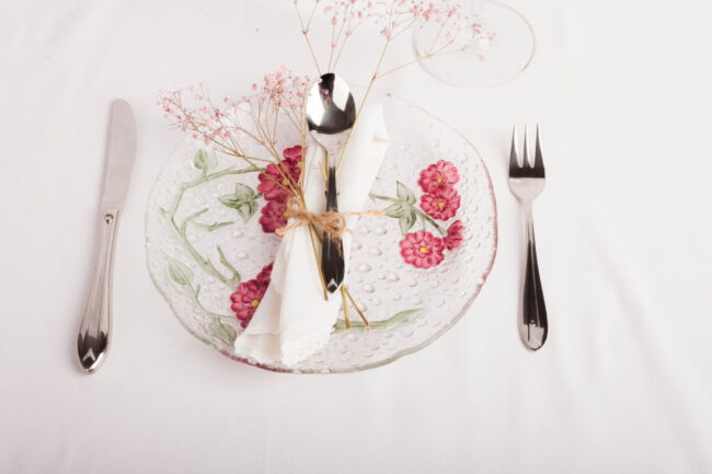 cubiertos de acero inoxidable sobre mesa y plato decorativo, imagen aspiracional comercial