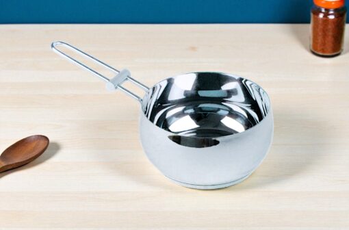 cazo de acero inoxidable napoles de 16 cm sobre un fondo de mesa de una cocina, se alcanza a visualizar parte de una cuchara de madera y un condimentero